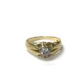 An 18ct gold ring set with a central diamond, the