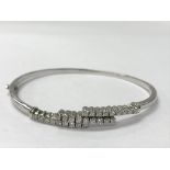 A white 18ct gold bangle with three rows of diamon