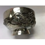 A Chinese silver bowl with raised dragon .