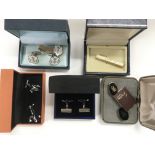 A collection of boxed cufflinks and tie pins.