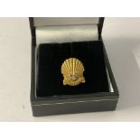 A 9ct gold shell lapel badge. 25 years service.