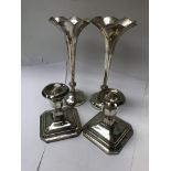 A pair of silver bud vases and a pair of candle st