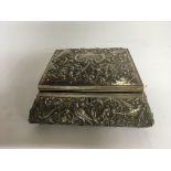 An elaborate silver trinket box with a lined inter