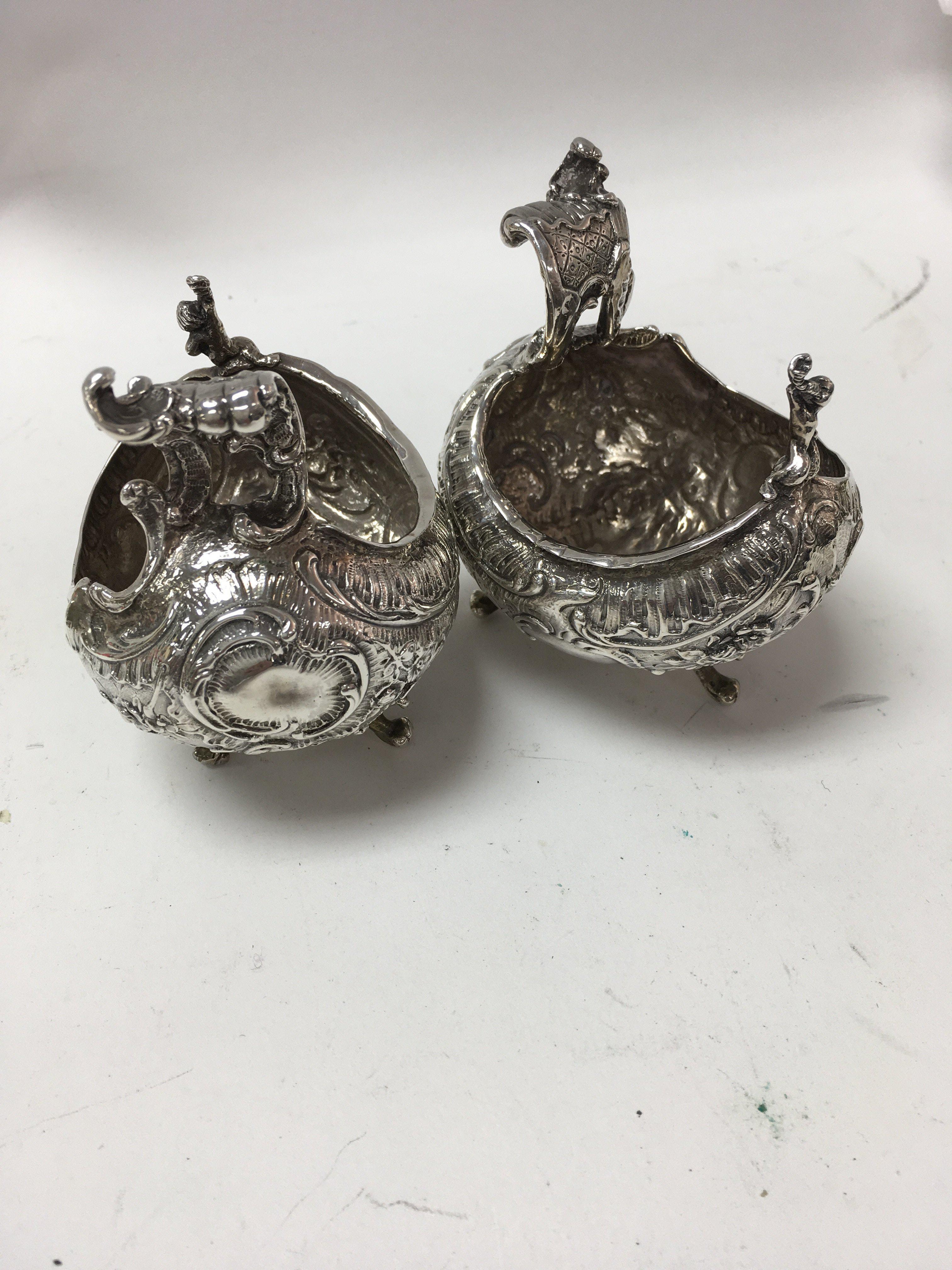 A pair of boat shaped silver salts with scrolled f