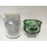 A green flashed glass and cut bowl on a stepped ba