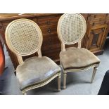 A pair of limedwood double cain bergere chairs wit