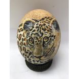 An Ostrich egg shell decorated with a Tigers Head,