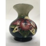 A small Moorcroft vase decorated with an orchid. S