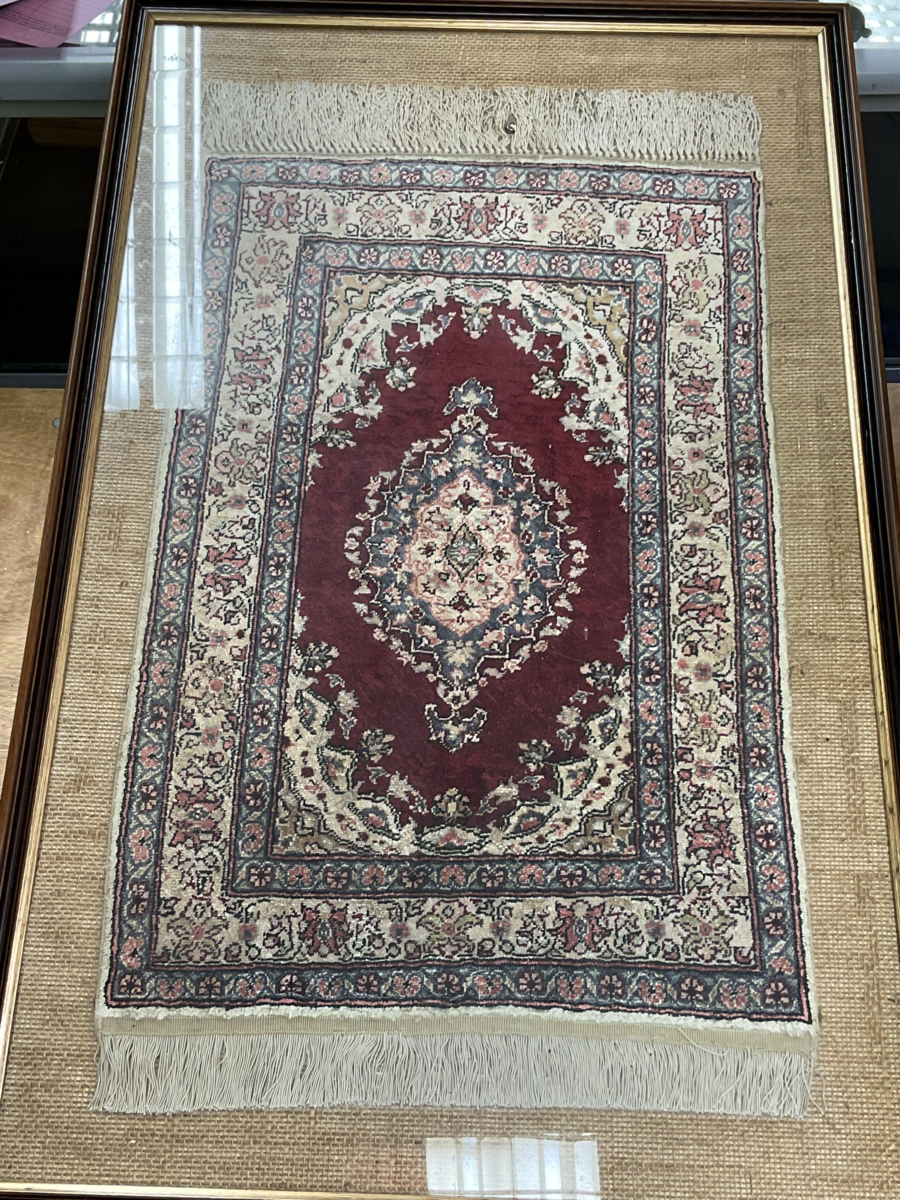 A framed silk rug measuring approximately 58.5cm x