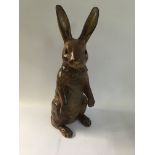 A Victorian pottery hare with glass eyes and brown