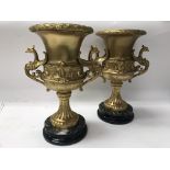 A pair of heavy Victorian gilded urns on marble ba