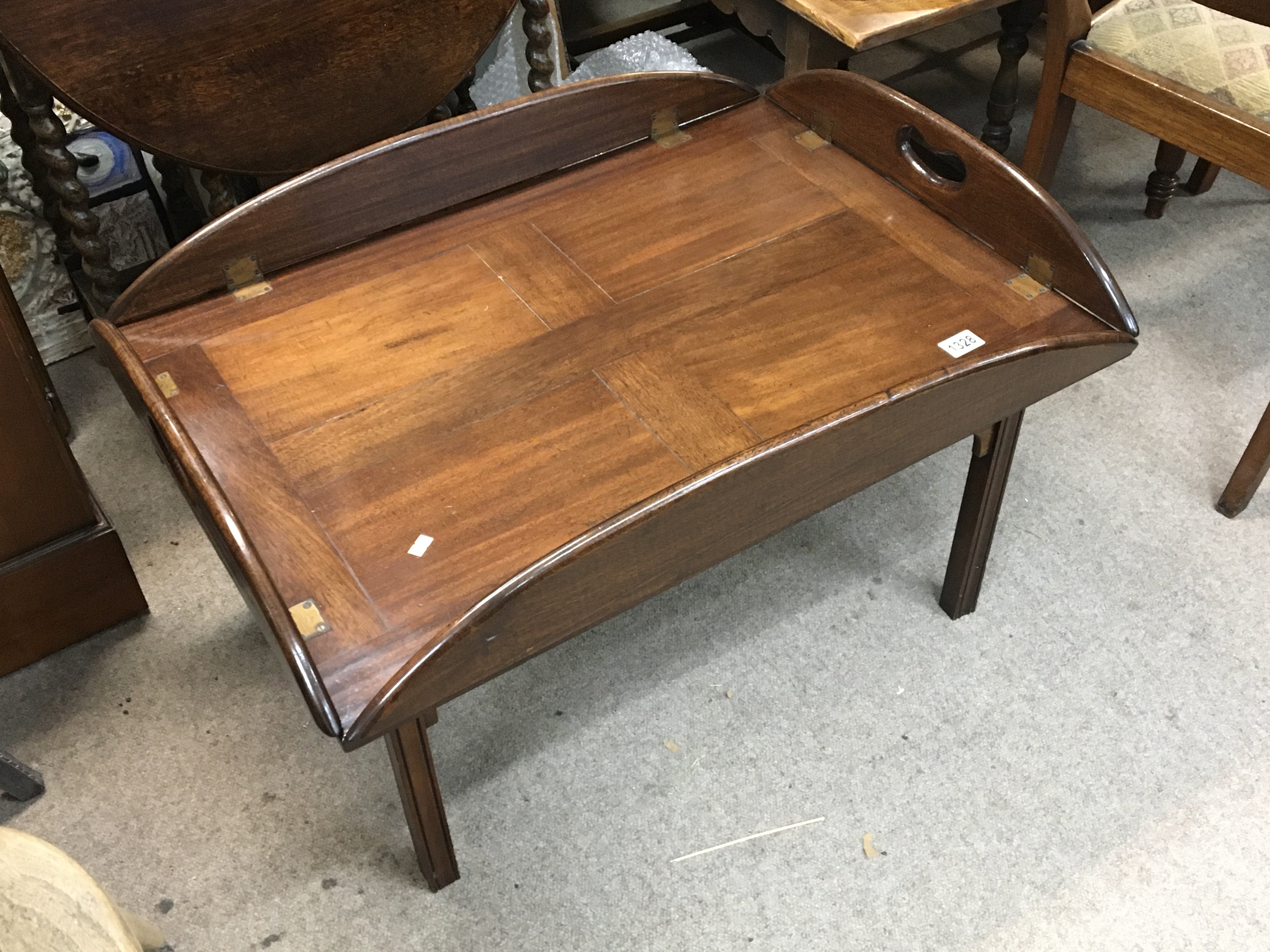 A Mahogany butlers tray with hinged sides on a squ