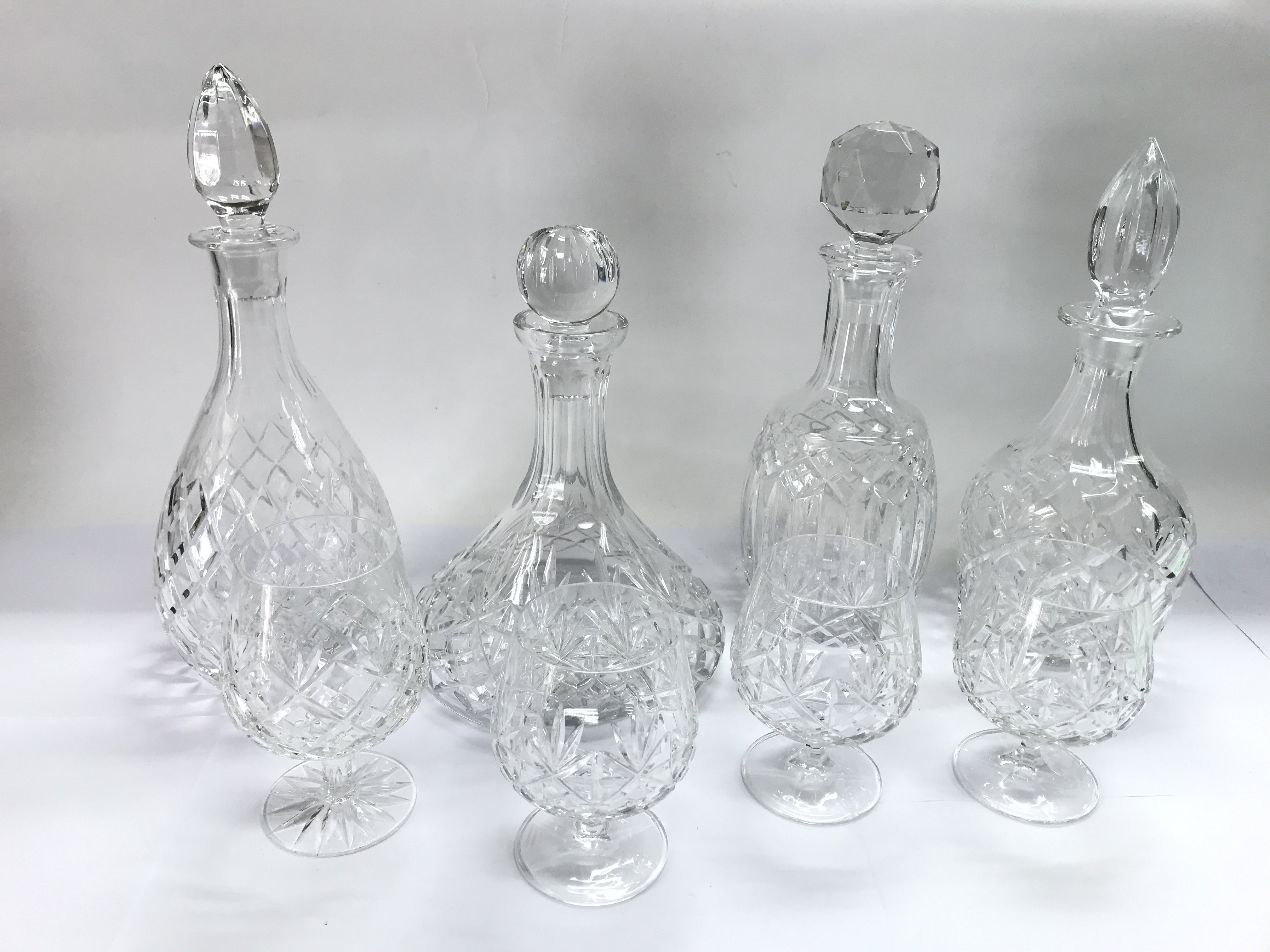 Four crystal and glass decanters and four glasses.