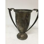 A silver trophy cup with shaped handles and person