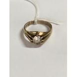 A 9 ct gold ring inset with a single clear stone .