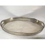 A silver plated tea tray with a shaped edge.