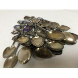 A collection of silver and enamel spoons depicting