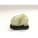 A jade figure of a recumbent elephant raised on a