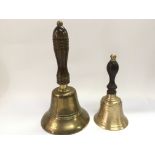 Two brass hand bells with wooden handles.