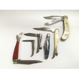A collection of six collectable pocket knives .