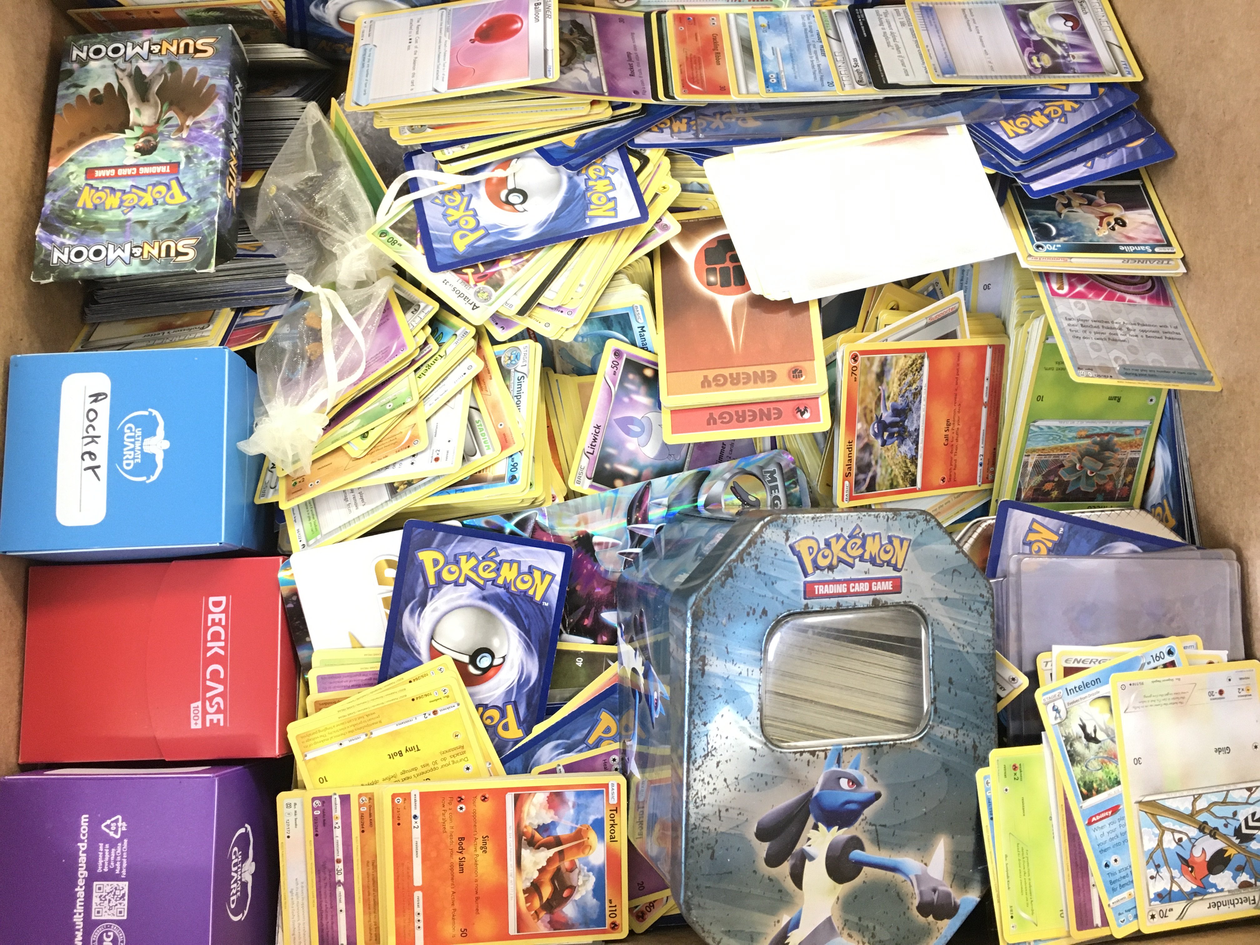 A Box Containing a Collection of Modern Pokemon Ca