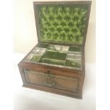 A walnut jewellery box with a hinged top. above tw