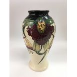 A boxed Moorcroft baluster vase with floral decoration on an ivory coloured ground, approx height