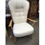 A blonde Ercol open arm chair with cream fabric cu