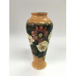 A boxed Moorcroft MCC 1997 vase by Emma Bossons with floral decoration on an orange and green