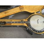 A cased four string banjo