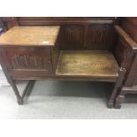 An oak window seat with linen fold panels on turne