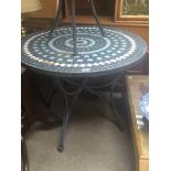 A metal garden table with a mosaic top. 73cm high