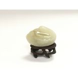 A jade figure of a duck raised on a hardwood stand