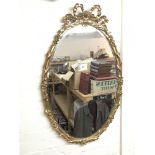 A gilt gramed oval mirror with scroll top, approx