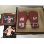 A pair of signed boxing gloves with photos the glo