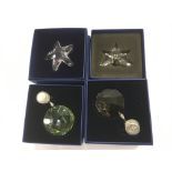 Four boxed Swarovski crystal ornaments.