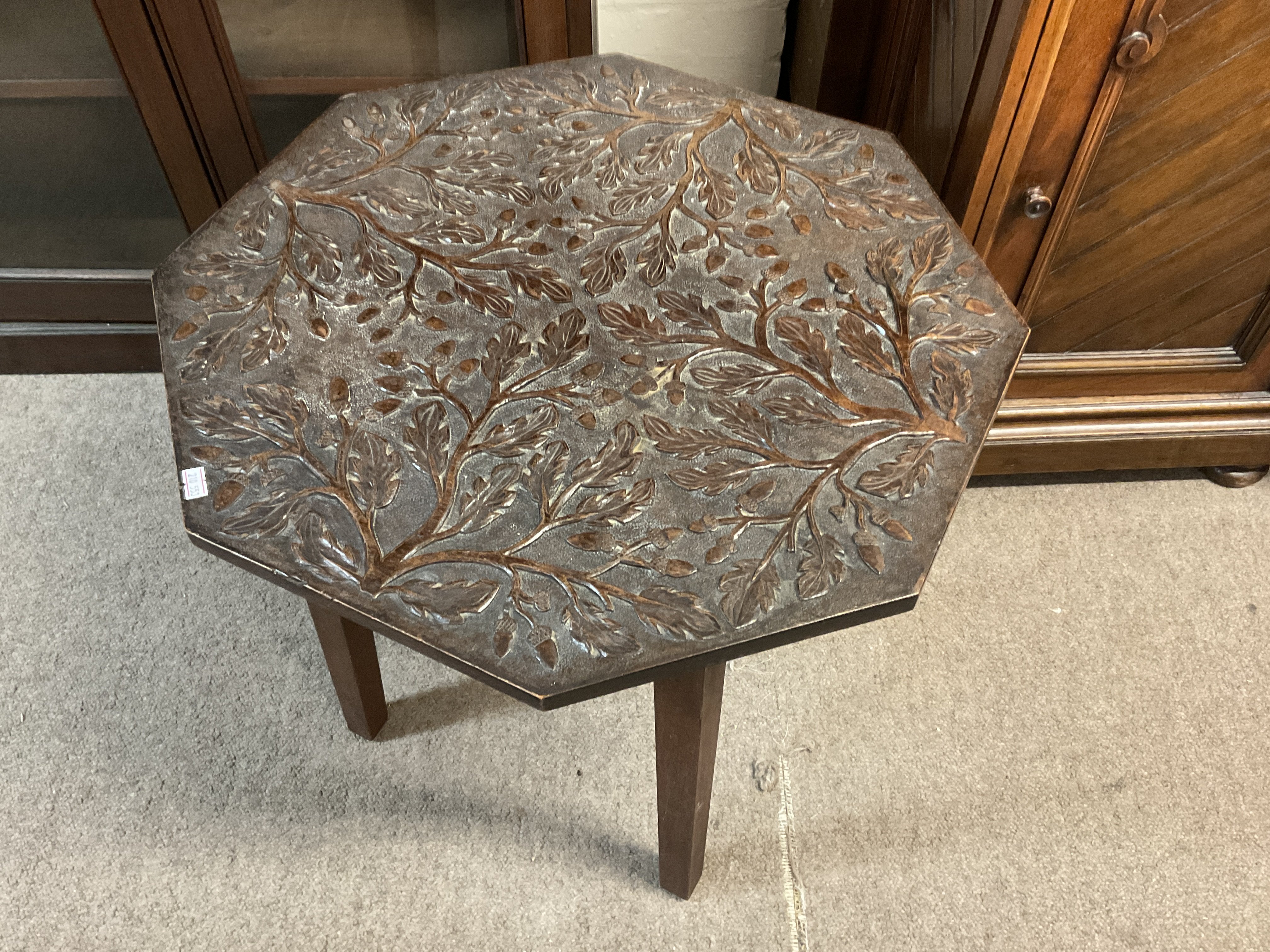 A carved oak hexagonal table with acorn and oak le