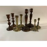 Four pairs of candle sticks. 2 sets made of brass and 2 sets made of wood. No reserve.