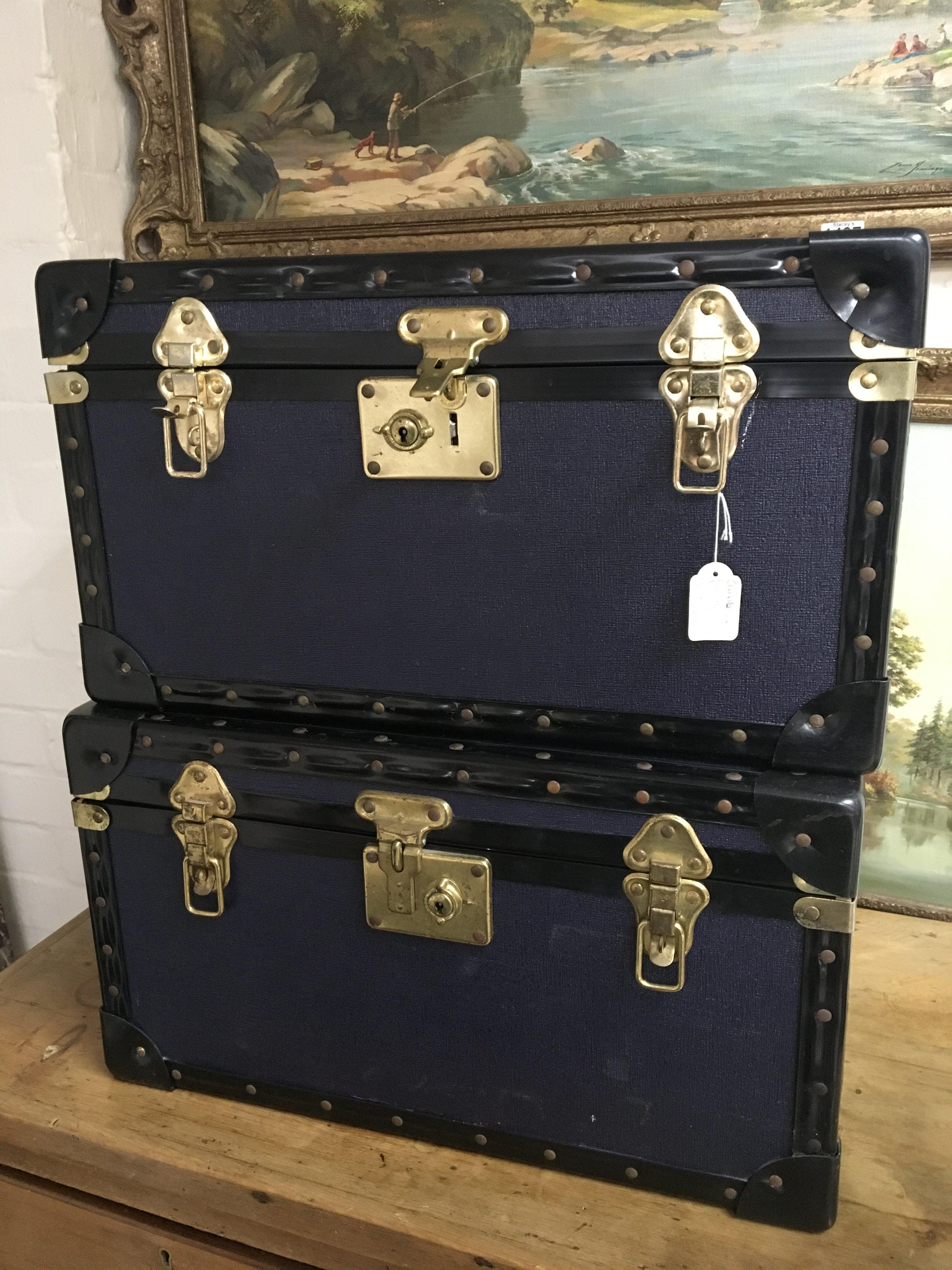 Two blue and black edge storage trunks with brass
