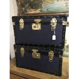 Two blue and black edge storage trunks with brass