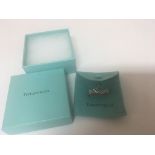 A silver Tiffany and Co ring with heart symbol.