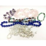 A collection of gemstone necklaces and a bracelet.