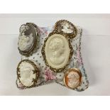 Five old cameo brooches (on cushion)