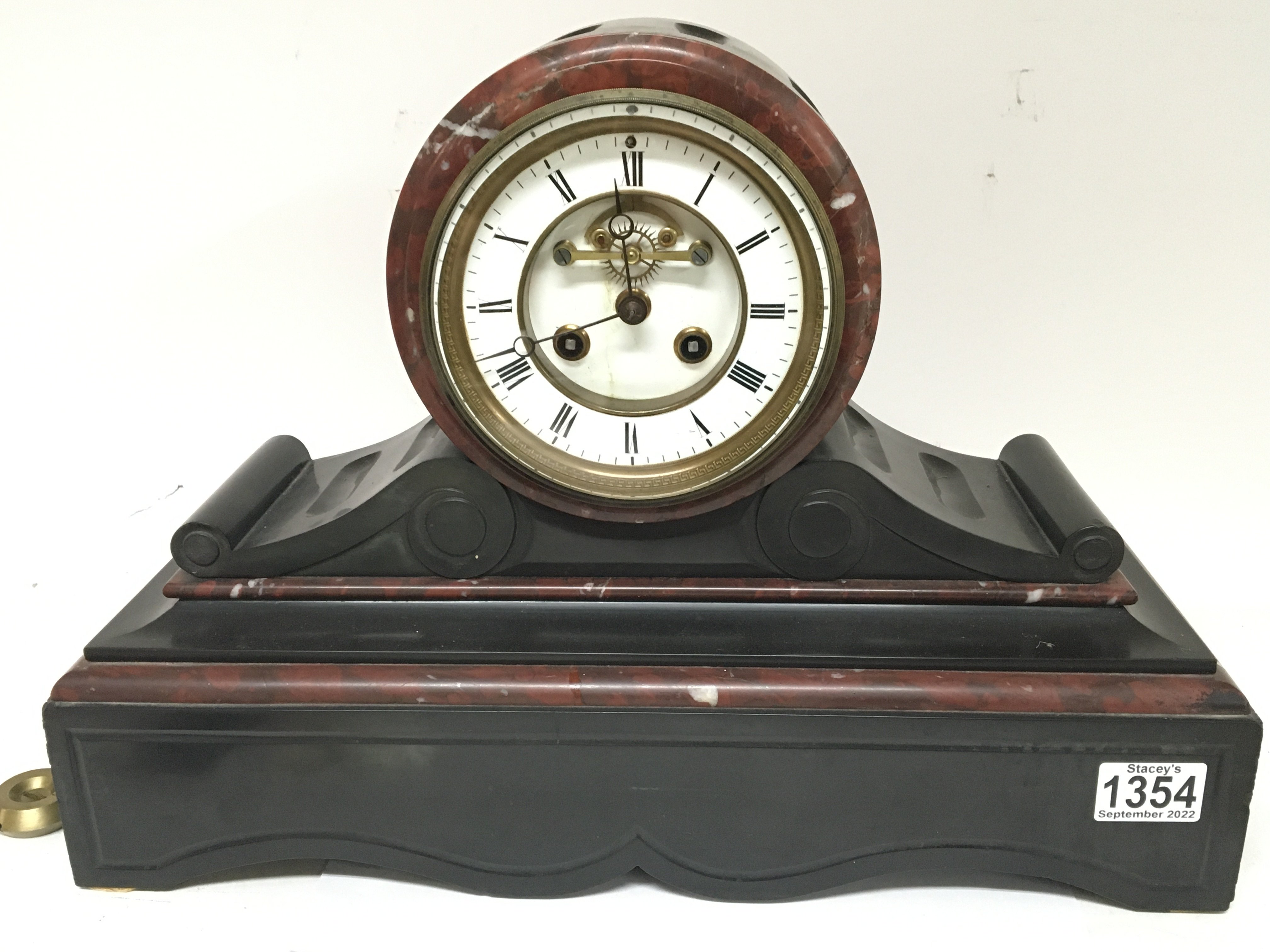 A Victorian black slate and marble mantel clock with a visible escapement. 45cm wide