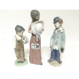 Three Lladro porcelain figures a clown lady with a hat and a young boy holding a football. (3)