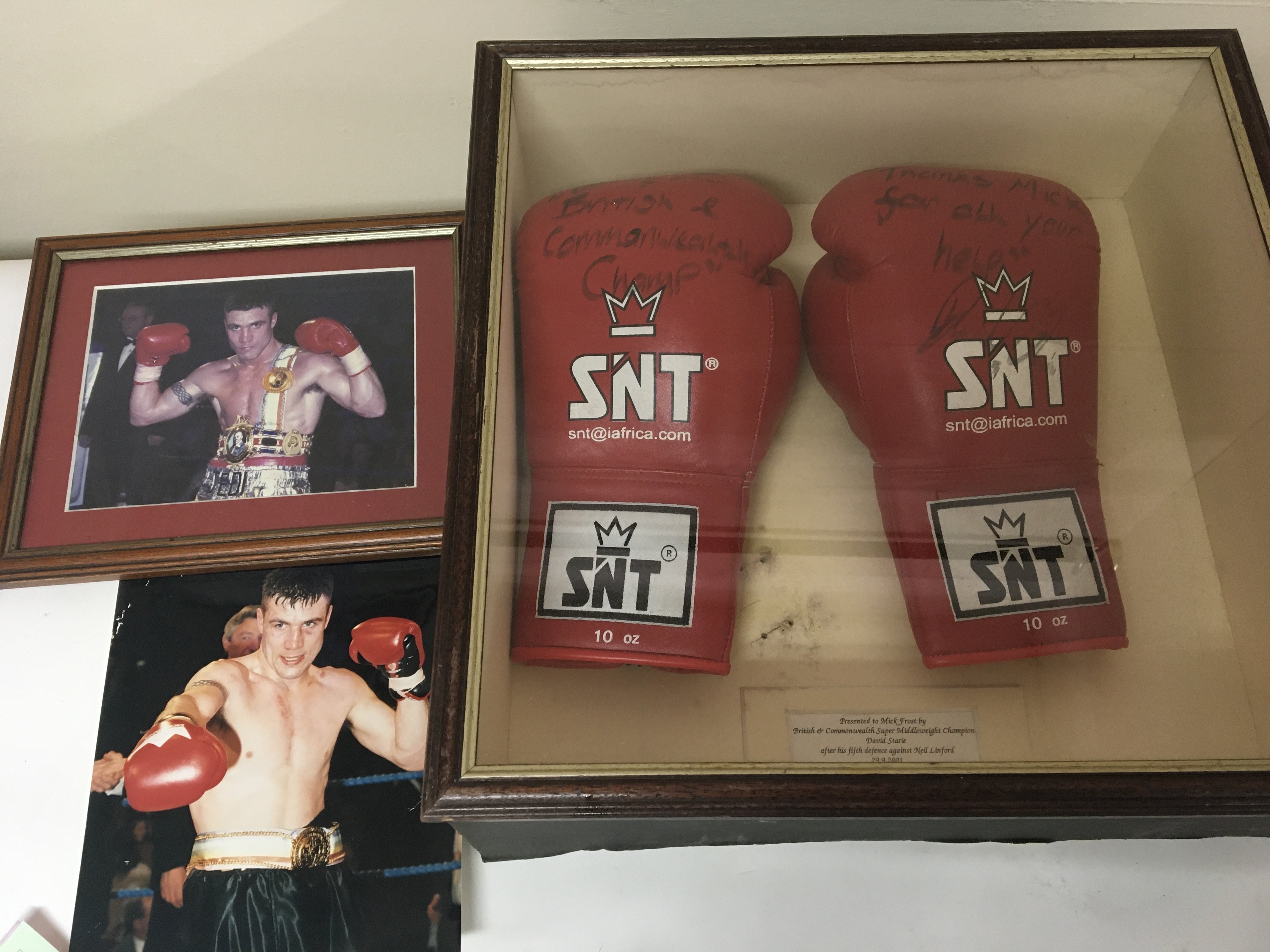 A pair of signed boxing gloves with photos the glo