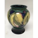A Moorcroft vase decorated with leaves and berries