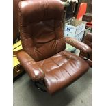 A 1970s retro leather open arm chair with matching stool .