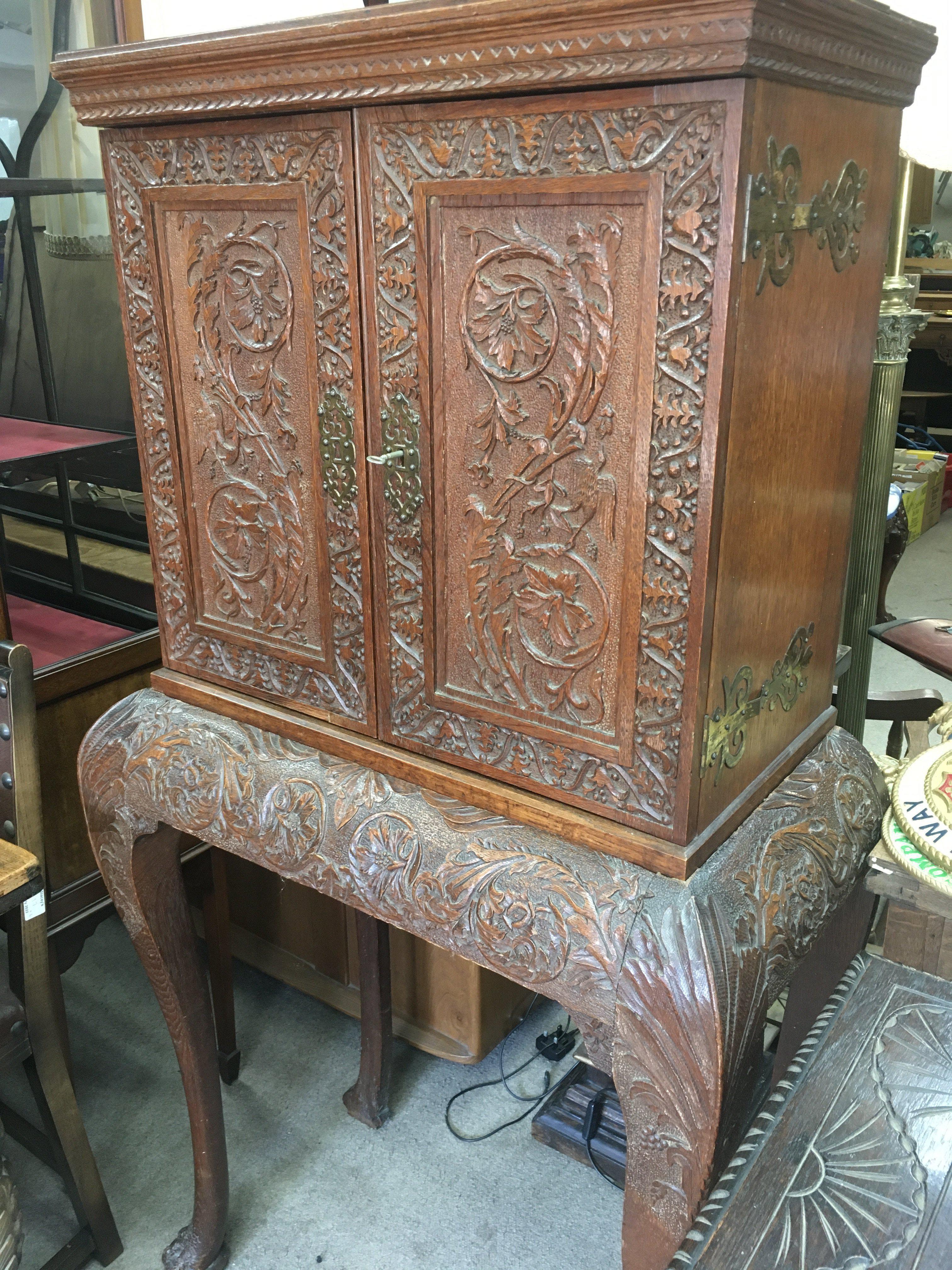 A oak oak cabinet The pair of carved doors enclosi