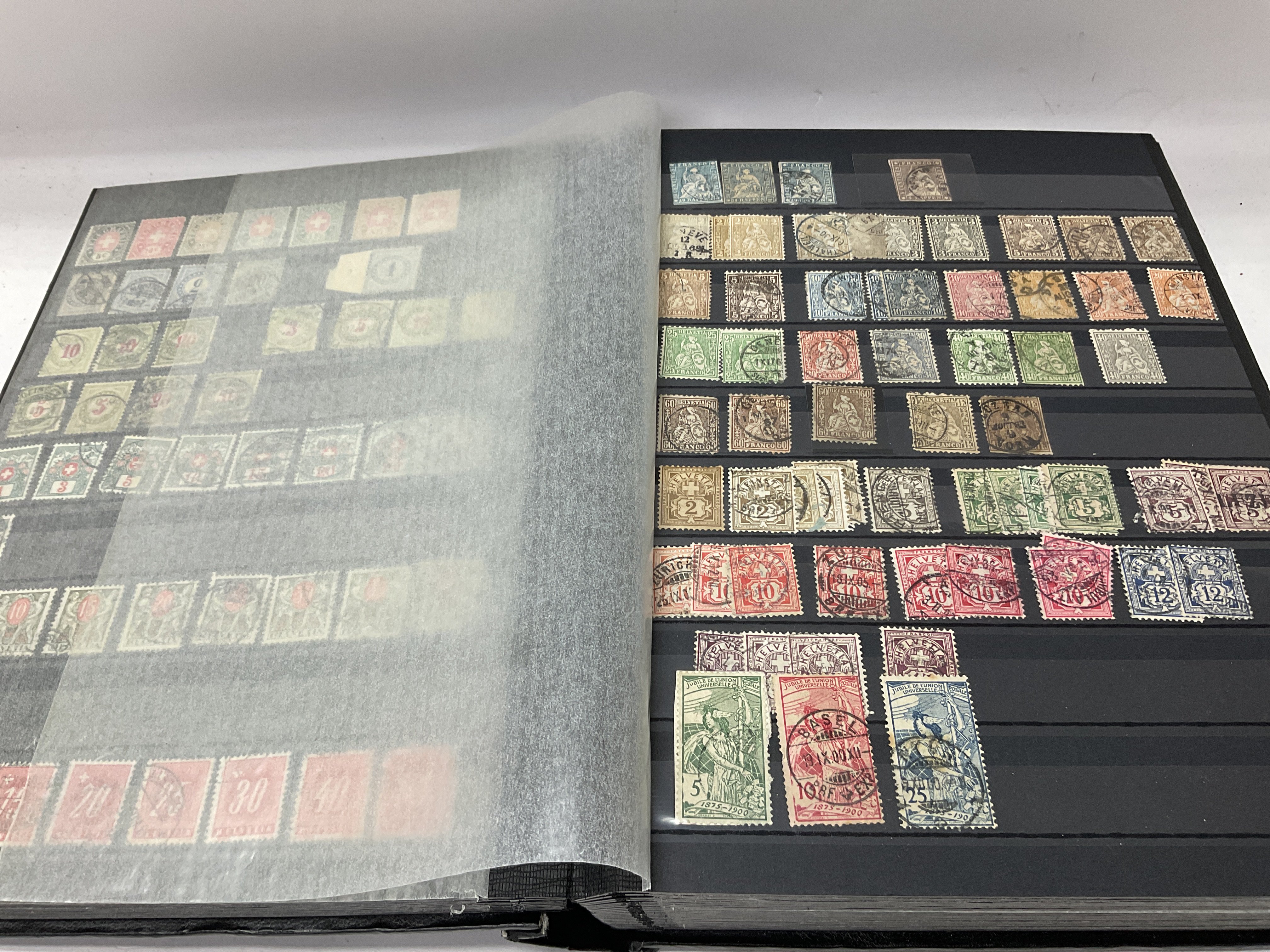 A large stock book includes Switzerland and Italy stamps.